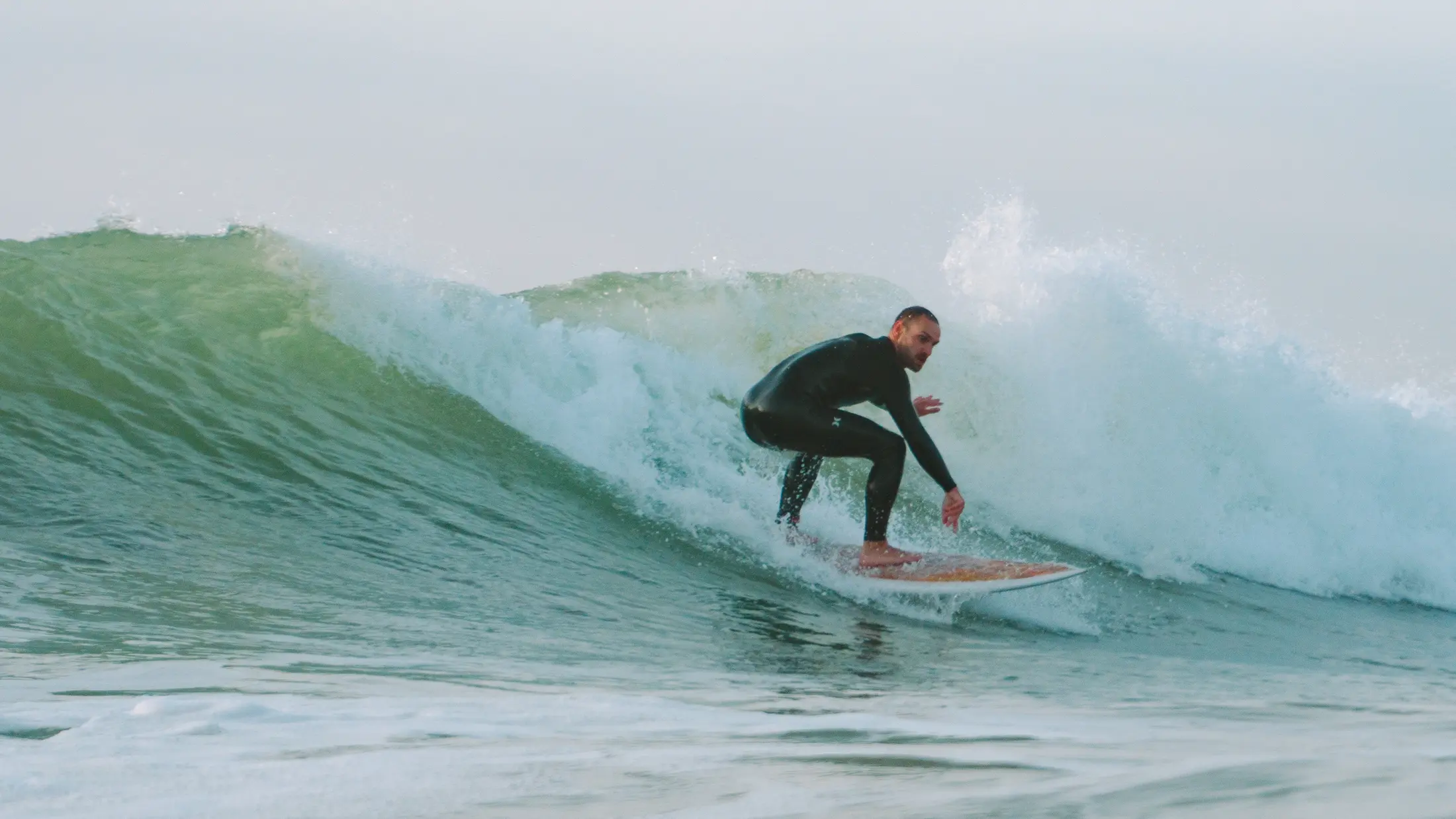 Surfer riding a clean green wave